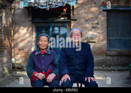 (171221) -- ZHENGZHOU, 21 décembre 2017 (Xinhua) -- un couple d'aînés posent pour une photo devant leur maison avant de passer à la réinstallation à Wanghei Village de Sunkou Taiqian County, ville située dans la province du Henan en Chine centrale. Le 1 novembre 2017. À partir de la fin de 2014, le gouvernement provincial du Henan a organisé un projet pilote de lutte contre la pauvreté La pauvreté à déménager 14 villages le long du fleuve Jaune à partir de la zone inondable de nouvelles colonies, tout en encourageant les villageois réinstallés à développer l'agriculture de l'industrie et du tourisme pour augmenter leur revenu. En août dernier, le projet a été officiellement approuvé par la Chine. Banque D'Images