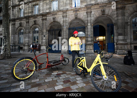 (171221) -- Paris, 21 décembre 2017 (Xinhua) -- le réparateur Yoann Andrieux Rapports sur son téléphone après avoir terminé l'entretien d'un vélo Ofo dans Paris, France, le 20 décembre, 2017. Deux semaines après son lancement ici, l'un des systèmes de partage de vélos populaires, Ofo, vise le leadership dans le marché en croissance rapide comme la ville s'efforce de promouvoir le transport vert pour réduire les émissions. La signature de l'entreprise vélo jaune vif peut être trouvé à la fois tranquille et venez visiter des coins de rue autour de la ville, et gagnent rapidement en popularité parmi les habitants et les touristes. (Xinhua/Chen Yichen) Banque D'Images