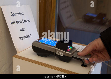 Duderstadt, Allemagne. Déc 20, 2017. Un homme utilise le processeur de carte de banque dans la basilique de Saint Cyriakus à Duderstadt, Allemagne, 20 décembre 2017. Dans cette paroisse catholique, les donateurs n'ont plus besoin d'argent pour appuyer le maintien de la basilique et peuvent apporter leur contribution par carte. Credit : Swen Pförtner/dpa/Alamy Live News Banque D'Images