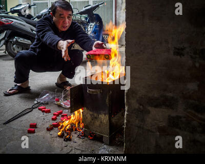 Hanoi, Hanoi, Vietnam. Dec 22, 2017. Un homme brûle de l'argent ''ghost'' près de sa maison dans le vieux quartier de Hanoi. Le vieux quartier est le coeur de Hanoi, avec des rues étroites et beaucoup de petites boutiques mais c'est était ''embourgeoisés'' parce que du tourisme et quelques magasins se transforment en hôtels et cafés pour les touristes et les riches vietnamiens. Crédit : Jack Kurtz/ZUMA/Alamy Fil Live News Banque D'Images
