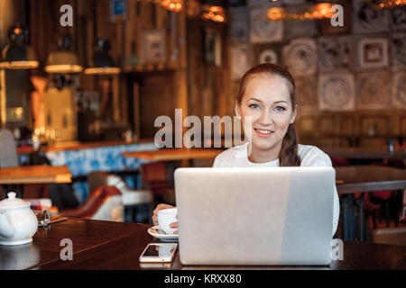 Yong femme un travail à laptop in cafe Banque D'Images