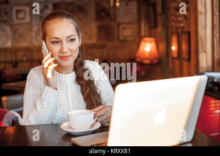 Yong femme un travail à laptop in cafe Banque D'Images