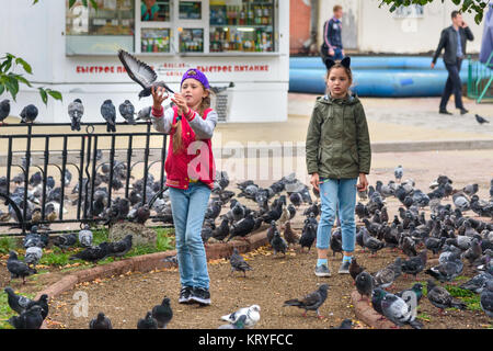 Irkoutsk, Russie - le 14 août 2017 : Deux jeunes filles russes nourrir les pigeons dans la rue dans le centre de la ville Banque D'Images