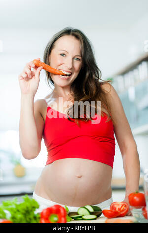 Schwangere Frau mit Gemüse beim Kochen - femme enceinte avec des légumes Banque D'Images