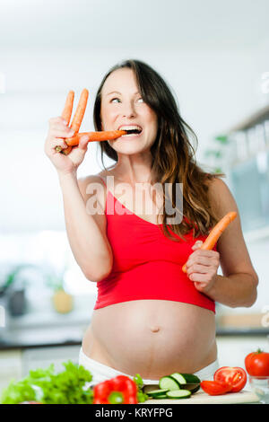 Schwangere Frau mit Gemüse beim Kochen - femme enceinte avec des légumes Banque D'Images