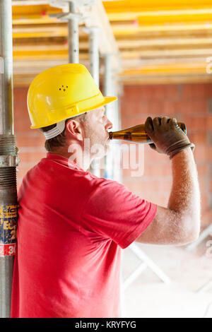 Bauarbeiter mit Bierflasche am Bau - building worker avec bouteille de bière au lot immeuble Banque D'Images