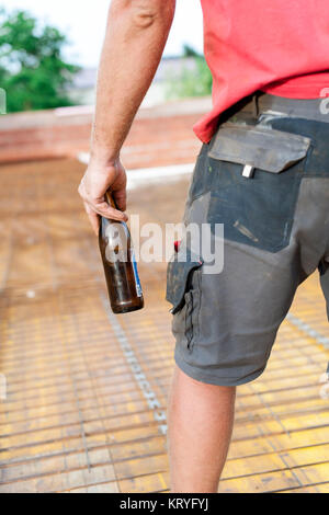 Bauarbeiter mit Bierflasche am Bau - building worker avec bouteille de bière au lot immeuble Banque D'Images