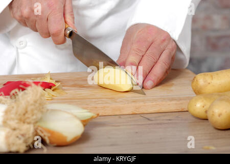 Détail des mains du chef de trancher les pommes de terre Banque D'Images