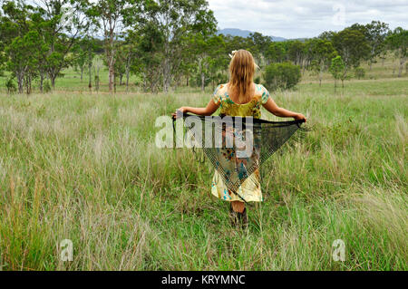 YOUNG WOMAN WALKING IN A FIELD Banque D'Images