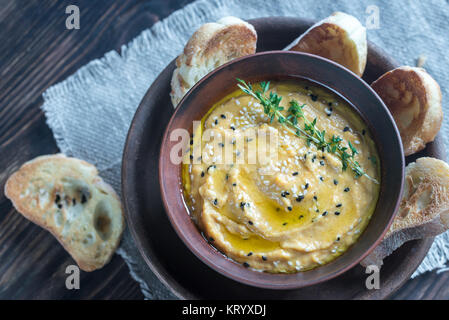 Bol de l'hummus de citrouille avec des tranches de pain grillé Banque D'Images