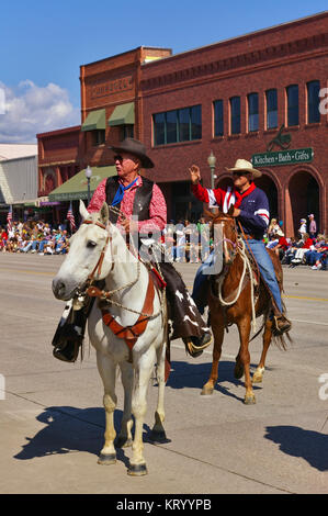 Cody, Wyoming, USA - 4 juillet 2009 - Deux coureurs salue les spectateurs alors qu'avec l'indépendance Day Parade Banque D'Images