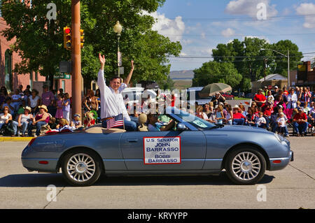 Cody, Wyoming, USA - 4 juillet 2009 - Le sénateur américain John Barrasso et son épouse Bobbi équitation dans une décapotable et forme tout en participant à l'Inde Banque D'Images