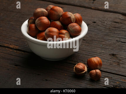 Groupe de coquilles de noix dans un bol, sur un fond de bois Banque D'Images