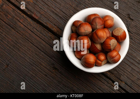 Groupe de coquilles de noix dans un bol, sur un fond de bois Banque D'Images