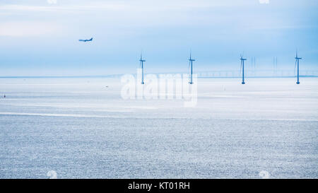 Avion, pont et éoliennes en mer dans le matin Banque D'Images