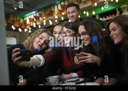 Groupe d'adolescents positive faire autoportraits et passer du temps dans un café. Banque D'Images