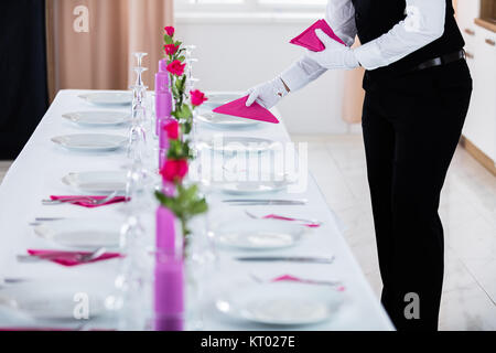 Waiter plaçant Napkin Banque D'Images