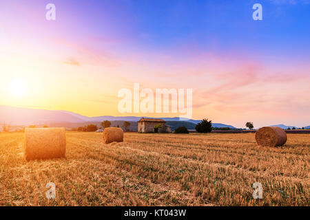 Coucher de soleil sur champ agricole avec des balles de foin près de Sault Banque D'Images