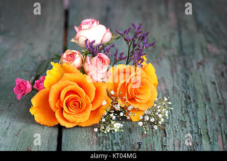 Bouquet de roses colorées sur une vieille table en bois Banque D'Images