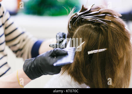 Le coiffeur dans le salon de beauté rend les cheveux coloration. young male hairdresser. Banque D'Images