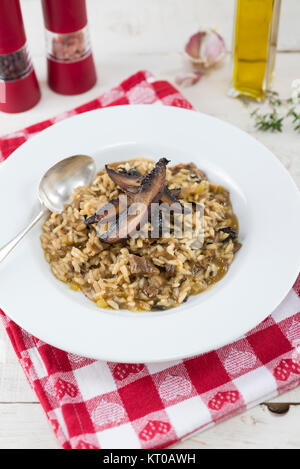 Risotto aux champignons sauvages garnie de tranches de champignons portobello rôti. Banque D'Images