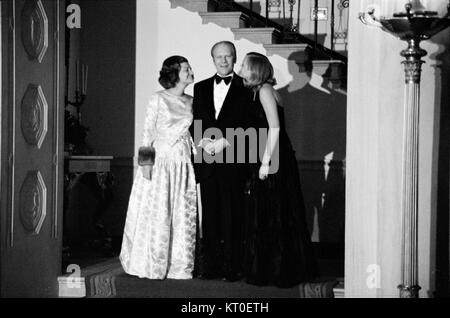 La photographie montre Betty Ford, son mari Gerald Ford (le 38e président des États-Unis), et leur fille Susan Ford à une fête de Noël. L'image capture un moment personnel en famille, mettant en valeur leur relation et l'esprit des fêtes dans la famille Ford. Banque D'Images