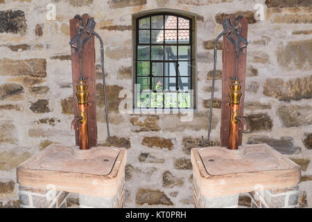 Zwei antike part Wasser Pumpen aus Kupfer in einem alten Gebäude. Banque D'Images