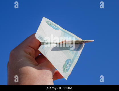 Coupures de l'argent russe, plié dans l'avion contre le ciel bleu dans la main Banque D'Images