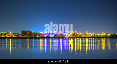 Une vue latérale de la plage de Dubaï avec réflexion de couleurs multiples. Un ensemble de petit bâtiment sur la vue avec fond de ciel bleu clair Banque D'Images