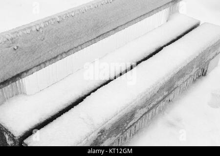 La pluie verglaçante couverts ce banc dans un parc Banque D'Images