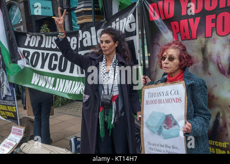 Une femme dans un keffieh donne un 'V' signe à Londres protester contre Tiffany contre la vente de "diamants du sang" du groupe Steinmetz qui a financé l'armée israélienne de la Brigade Givati, accusé de crimes de guerre. Banque D'Images