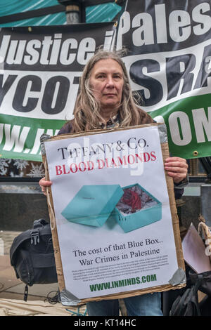 Une femme est titulaire d'une affiche 'Tiffany & Co. diamants du sang" à Londres protester contre la vente de "diamants du sang" du groupe Steinmetz qui a financé l'armée israélienne de la Brigade Givati, accusé de crimes de guerre. Ils sont les principaux fournisseurs de Tiffany. Banque D'Images