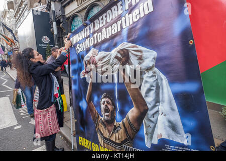 Protesetrs fixer une bannière contre l'apartheid israélien en dehors de Tiffany à protester contre la vente de "diamants du sang" du groupe Steinmetz qui a financé l'armée israélienne de la Brigade Givati, accusé de crimes de guerre. Banque D'Images