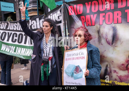 Une femme dans un keffieh donne un 'V' signe à Londres protester contre Tiffany contre la vente de "diamants du sang" du groupe Steinmetz qui a financé l'armée israélienne de la Brigade Givati, accusé de crimes de guerre. Banque D'Images