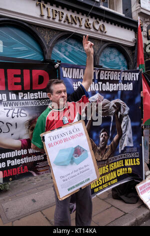 Un manifestant fait un 'V' signe à Londres protester contre Tiffany interdisant la vente de "diamants du sang" du groupe Steinmetz qui a financé l'armée israélienne de la Brigade Givati, accusé de crimes de guerre. Banque D'Images