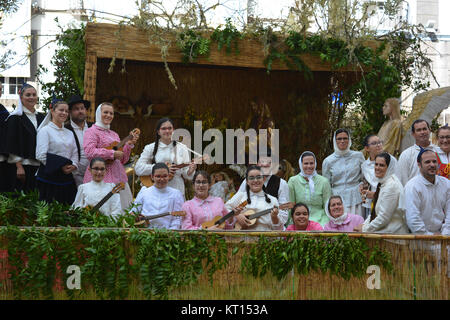 Musiciens et danseurs folkloriques posant pour l'appareil photo avec une scène de la nativité dans l'arrière-plan, l'Avenida de Arriaga, Funchal, Madeira, Portugal Banque D'Images