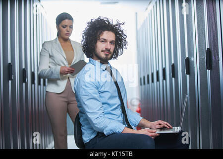 Deux jeunes techniciens qui travaillent dans un centre de données sur la maintenance des serveurs Banque D'Images