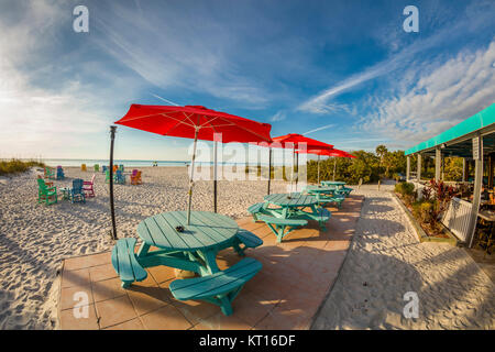 Tables de pique-nique et des chaises sur la plage par une journée ensoleillée au South Beach Bar & Grill sur Gasparilla Island Florida Banque D'Images