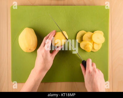 Découpage des mains en plastique vert pomme sur board Banque D'Images