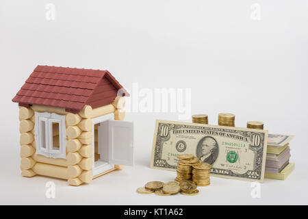 Toy house près de l'argent est d'acheter un lot de factures et une pile de pièces Banque D'Images