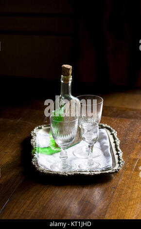 Bouteille de Chartreuse et verres dans un coin sombre. Banque D'Images