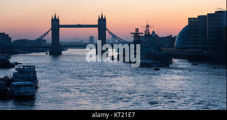 Londres, Angleterre, Royaume-Uni - 4 janvier 2010 : Tower Bridge et HMS Belfast sont silhouette sur le lever du soleil d'hiver vu le long de la Tamise, L Banque D'Images