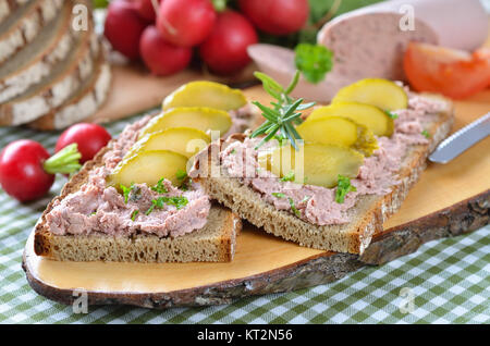 Pain de campagne avec saucisson sur une tranche de bois rustique Banque D'Images