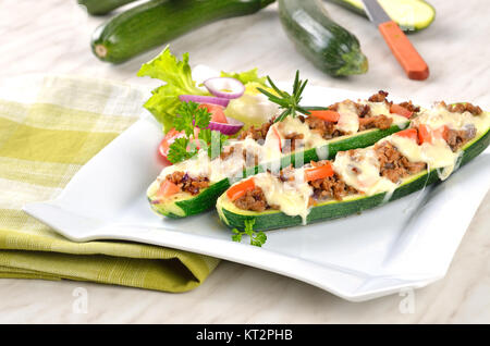 Les moitiés de courgettes farcies à la viande hachée et gratin avec de la mozzarella Banque D'Images