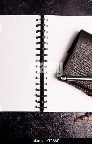 Couvert de cuir vintage ntoebook sur un journal ouvert sur une planche en bois foncé Banque D'Images