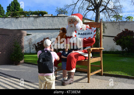 Couple de touristes en vacances au moment de Noël, prendre une photo avec le Père Noël sur un smartphone, Avenida Arriaga, Funchal, Madeira, Portugal Banque D'Images