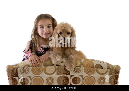 Jeune fille et golden cocker anglais chiot sur un fauteuil sur le dessus du dos à l'appareil photo côte à côte avec un sourire heureux Banque D'Images