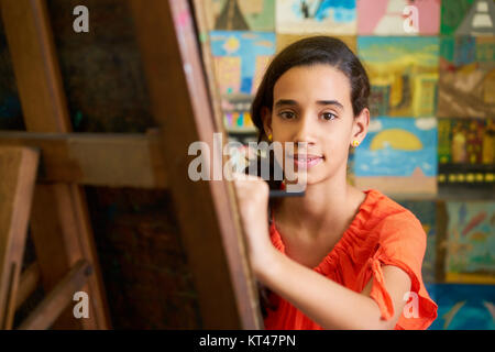 École d'art, College of Arts. Portrait of happy young girl smiling, apprendre à peindre et à la recherche à l'appareil photo. Banque D'Images