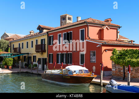 Water taxi stationné en face de bâtiments colorés aux côtés du canal principal de l'île de Torcello, lagune de Venise, Italie Banque D'Images