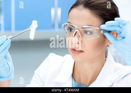 Portrait de chercheur scientifique à des lunettes et des gants à l'échantillon de produits chimiques Banque D'Images